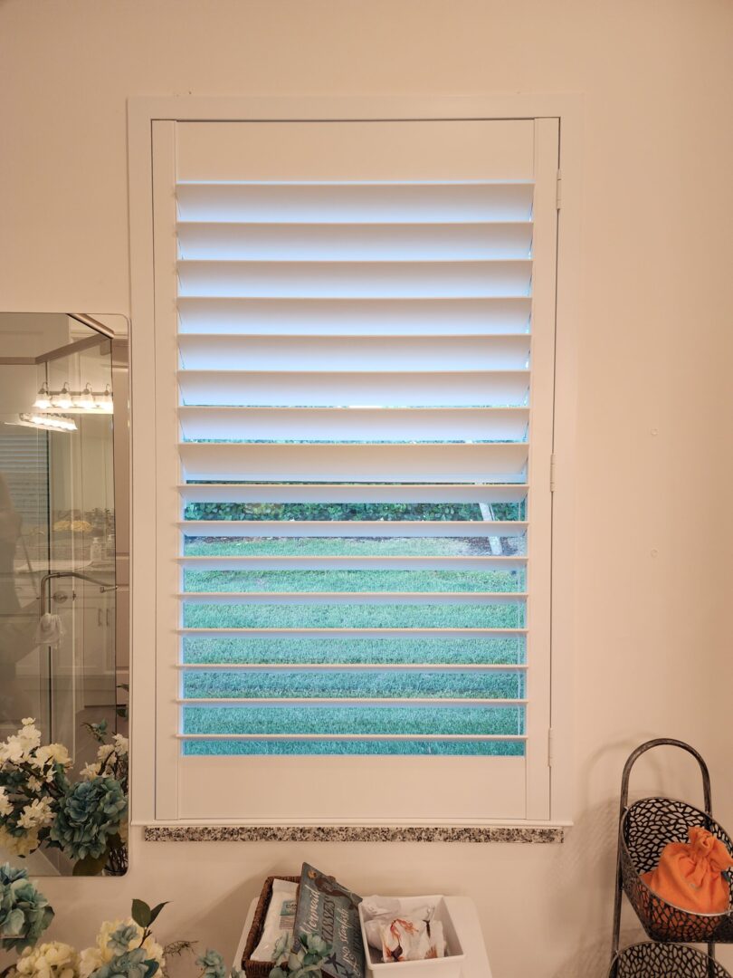 20240702_164520 White window shutters with view of grass.